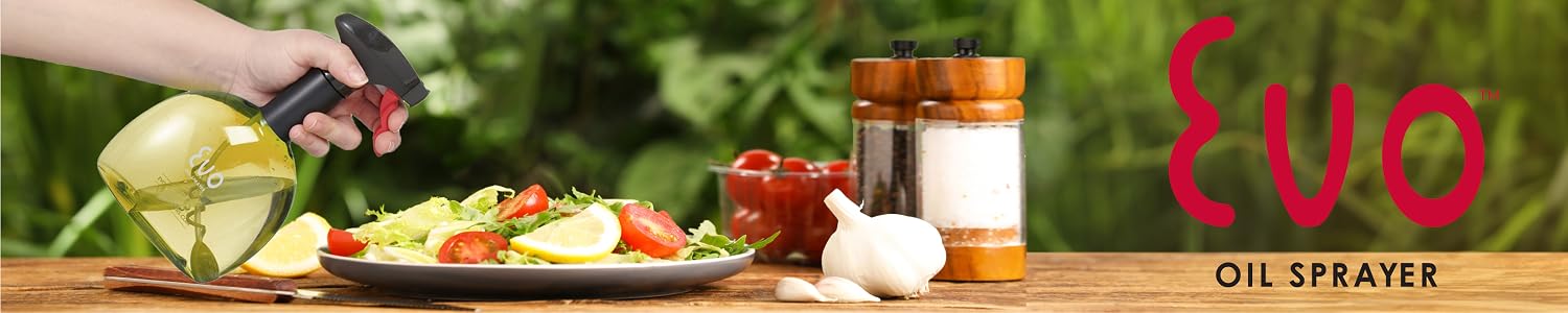 Hand spraying olive oil over a fresh salad with an Evo sprayer